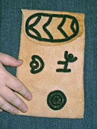 Small pouch decorated with beadwork forming glyths.